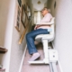 Frau nutzt Treppenlift in ihrem Haus