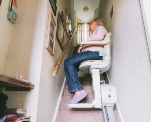 Seniorin benutzt Treppenlift in ihrem Haus