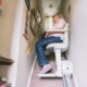 Seniorin benutzt Treppenlift in ihrem Haus