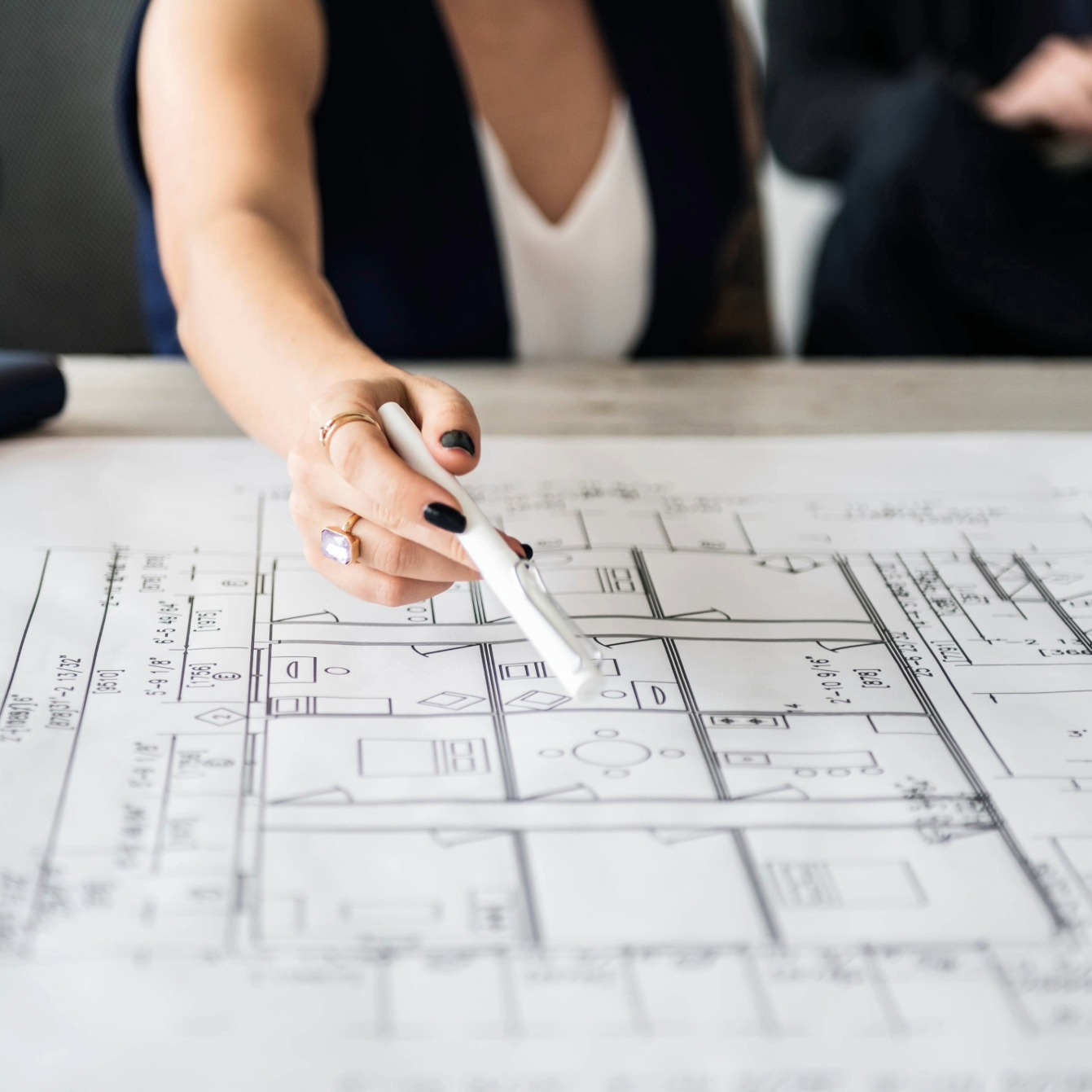 Bauplanung für einen Treppenlift Hand zeigt auf einen Grundriss bei der baulichen Planung eines Treppenlifts