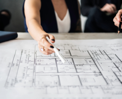 Hand zeigt auf einen Grundriss bei der baulichen Planung eines Treppenlifts